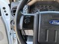 Close-up of the steering wheel of a 2008 Ford F-550 featuring a black control panel with buttons for setting and resuming speed as well as an airbag emblem