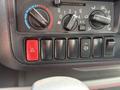Control panel of a 2018 Hino 195 featuring climate control knobs buttons for hazard lights and other functions