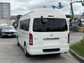 A white 2009 Toyota Hiace van parked with its rear facing the viewer displaying the Toyota emblem and sliding side door