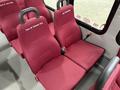 Interior seating of a 2017 Ford E450 with maroon upholstery and seat belts featuring names embroidered on the backs of two adjacent seats