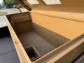 An open tan storage box in the bed of a 2021 Ford F-350 SD featuring a smooth interior and a compartment along one side