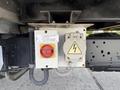 A control panel featuring a red power disconnect switch and a yellow electrical outlet on a 2023 Ford E-450 vehicle