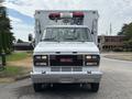 A 1994 GMC Vandura 3500 van with a white exterior and red GMC logo on the front grille, featuring side mirrors and a box truck structure behind it