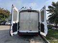 A 2016 Ford Transit 150 van with its rear doors open, revealing a metal-lined cargo area with a lockable door inside