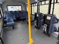 Interior of a 2017 Chevrolet Express showing multiple rows of blue fabric seats and a central vertical yellow pole