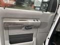 Interior door panel of a 2011 Ford Econoline featuring a handle window controls and speaker grille in a light gray color