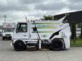 A white 2012 Global M4 street sweeper with a green and yellow logo and a front-mounted broom for cleaning streets