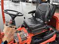 A close-up view of the seat and controls of a 2012 Kubota F3680 tractor showing a black seat steering wheel and various control levers