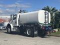A 2022 Freightliner M2 106 truck with a large cylindrical tank attached to the rear and hoses coiled on the side