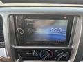 Dashboard display of a 2012 Hino 338 showing a Clarion stereo interface tuned to FM radio station 99.3 MHz with various control knobs below it