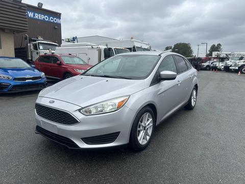 A silver 2018 Ford Focus with a sleek design and five-spoke alloy wheels parked at an outdoor location