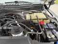 Close-up of the engine bay of a 2020 Ford F-550 showing various components including a battery reservoir hoses and an engine cover