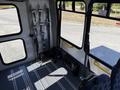 Interior of a 2015 Ford Econoline with gray flooring and seatbelt fixtures visible along the walls