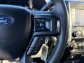 Close-up of the steering wheel of a 2020 Ford F-350 featuring audio control buttons and a phone control button