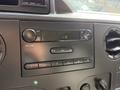 Dashboard of a 2019 Ford Econoline featuring a radio control panel with buttons for volume tuning and station selection displaying the time 119