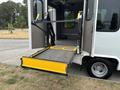A 2014 Ford E-350 with a wheelchair lift extended from the side doors into a flat position