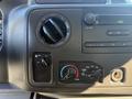 Dashboard controls of a 2019 Ford E-450 featuring air conditioning vents a radio display and temperature adjustment knobs