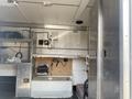 A 2008 Wells Industries Inc EW1422 trailer interior featuring cabinets shelves and a work area with tools and equipment visible