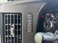 Close-up of the dashboard controls of a 2020 Chevrolet Express featuring buttons for lights hazard warning and other functions alongside a vent and gauges