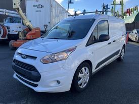 A white 2017 Ford Transit Connect with a black grille and roof rack parked at a location with industrial equipment in the background