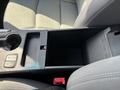 A 2015 Hyundai Sonata's center console showing storage compartment and buttons for features like seat heating