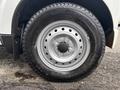 A close-up of a silver alloy wheel with a black tire featuring a tread pattern displaying the size 145R12 and brand name Yokohama