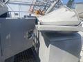 A 2010 aluminum 16 foot boat with a gray finish featuring a storage compartment and a removable lid