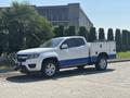A 2017 Chevrolet Colorado pickup truck with a white body and blue accents featuring a tool box in the truck bed and equipped with a winch on the front