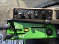 Control panel of a 2021 John Deere 1575 featuring levers switches and gauges for operating the machine