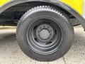 A close-up view of the tire and wheel of a 2010 Ford F-550 Super Duty featuring a black wheel and a treaded tire labeled Greenlander 225 75R 16