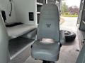 A gray upholstered driver's seat from a 1994 GMC Vandura 3500 featuring a distinctive emblem on the backrest