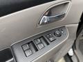 An interior door panel of a 2014 Honda Odyssey featuring window control buttons and a sleek handle design
