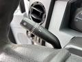 Close-up of a steering column control lever from a 2013 Ford F-250 SD featuring settings for windshield wipers and headlights
