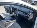 Interior view of a 2014 Mercedes-Benz CLA-Class showing black leather seats dashboard and steering wheel with modern controls and infotainment display