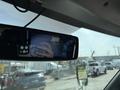 A 2020 Chevrolet Express van viewed from the interior with a focus on the rearview mirror showing the reflection of a hand and part of the dashboard