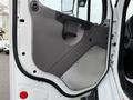 Door panel of a 2015 Freightliner M2 showing a grey interior design with a handle and metallic surface at the bottom