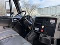 Interior of a 2011 International 4300 truck showing the dashboard steering wheel and control panels with various buttons and gauges