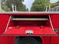 A red 2015 Chevrolet Silverado 3500HD truck featuring an open toolbox with a diamond plate lid and a measuring tape inside