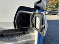 Close-up of the charging port on a 2022 Lion Lion6 electric vehicle showing an indicator light and a labeled cover