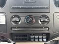Dashboard controls of a 2009 Ford F-450 Super Duty featuring climate control dials and auxiliary switches