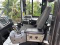 Interior of a 2012 Caterpillar 980 loader showing the driver's seat controls and dashboard with various instruments and levers