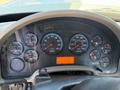 Dashboard of a 2013 International 7400 featuring various gauges for RPM, speed, fuel, and temperature with a digital display and multiple warning lights