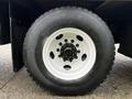 Close-up of a white wheel and tire from a 2007 GMC F7500 featuring a multi-bolt pattern and rugged tread design