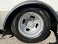 A close-up of a silver rim and tire from a 2017 Chevrolet Express showcasing the wheel design and tread pattern