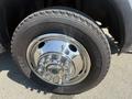 A close-up of a chrome wheel hub on a 2011 Dodge Ram 5500 featuring a large tire with prominent tread and detailed lug nuts visible