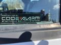A 2016 Ford F-250 SD with a security system sticker on the driver's side window