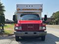 A red 2007 GMC C4500 TopKick with a white delivery box mounted on the back and dual side mirrors