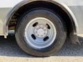 A close-up of a silver wheel and tire from a 2020 Chevrolet Express showcasing the tire tread and wheel design