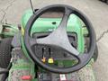 Close-up of the steering wheel and control panel of a 2009 John Deere 2653B Precision mower showing various levers and buttons