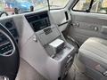 Interior of a 1994 GMC Vandura 3500 featuring a dashboard with controls and a stereo system a central console and upholstered seating